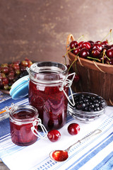 Berries jam in glass jar on table, close-up