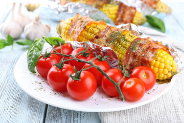 Grilled bacon wrapped corn on table, close-up