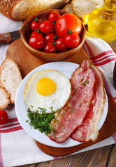Scrambled eggs with bacon and vegetables served
