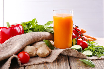 Glass of fresh carrot juice and vegetables
