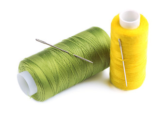 Needles and spools of thread isolated on white