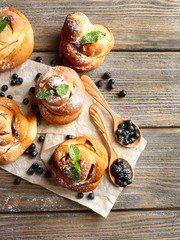 Tasty buns with berries on table close-up
