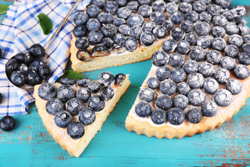 Tasty homemade pie with blueberries on wooden table