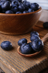 Wooden bowl of blueberries on cutting board on wooden