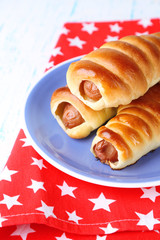 Baked sausage rolls on plate on table close-up