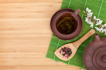 Japanese green tea and sakura branch over mat