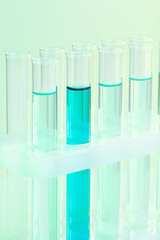 Test-tubes with blue liquid on light background