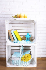 Wooden boxes with home things on white brick wall background