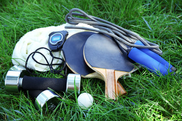 Assortment of sport equipment on green grass background