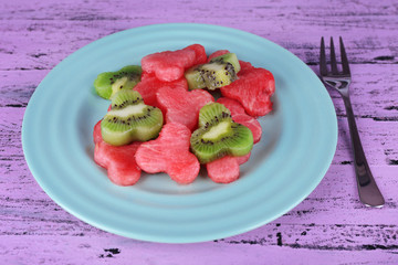 Slices of watermelon in plate on wooden background