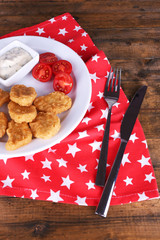Chicken nuggets with sauce on table close-up