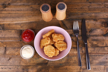 Chicken nuggets with sauces on table close-up