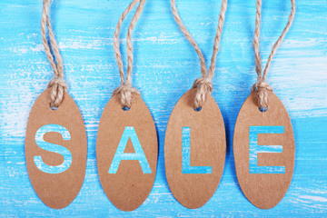 Sale tags on blue wooden background