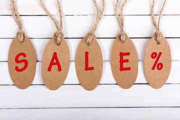 Sale tags on white wooden background