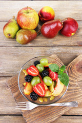 fresh tasty fruit salad on wooden table