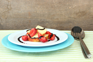 fresh tasty fruit salad on table, on wooden background