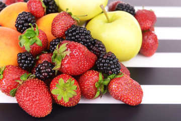 Ripe fruits and berries on striped background
