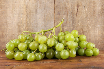 Green grape on wooden table on wooden background