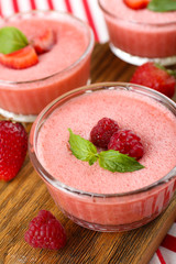 Delicious berry mousse in bowls on table close-up