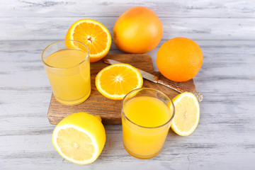 glasses of juice with fresh fruits on grey wooden table