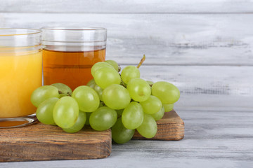 glasses of juice with fresh fruits on grey wooden table
