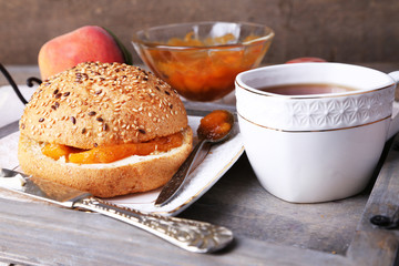 light breakfast with cup of tea and homemade jam on wooden
