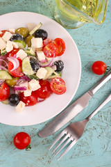 Greek salad in plate on wooden background