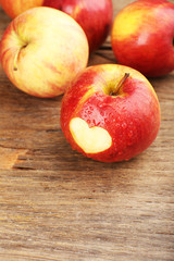 Naklejka na ściany i meble Red apple with heart on wooden table, close-up