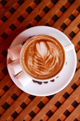 Cup of coffee with cute drawing in cafe