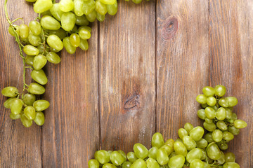 Bunch of ripe grapes on brown wooden background