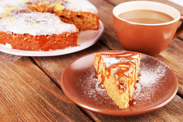 Delicious cake and cup of coffee on wooden table