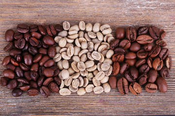 Naklejka premium Coffee beans on wooden background