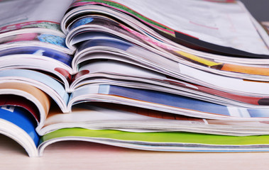 Magazines on wooden table on gray background