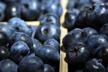 Tasty ripe blueberries in wooden crate, close up