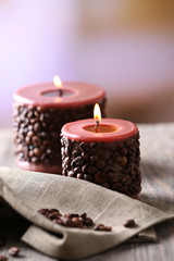 Fototapeta na wymiar Candle decorated with coffee beans on wooden table, close up
