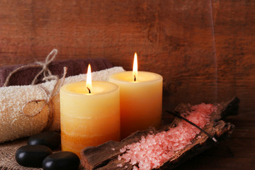 Spa stones with candles and sea salt on wooden background