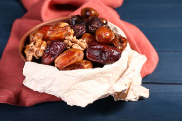 Tasty dates fruits in bowl, on blue wooden background