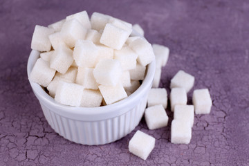 Refined sugar in bowl on color wooden background