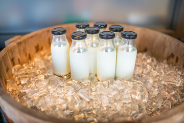 Closeup of bottles of milk set on ice wooden crate