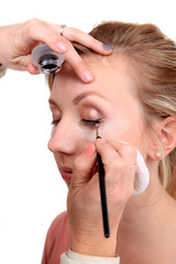 Makeup artist applying makeup to model