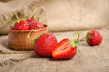 Ripe Strawberry in a wooden Bowl on burlap background