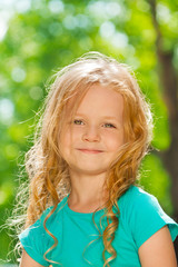 Close portrait of curly happy little girl outside