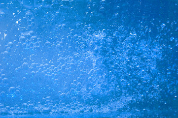 Blue drops of water on glass surface