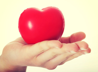 Obraz na płótnie Canvas Red heart held on a female's hand.