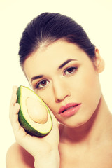 Beautiful woman's face with avocado.