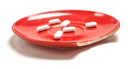 Bite off plate with white pills on the white background