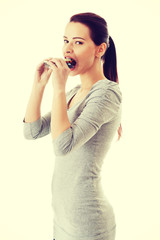 Casual beautiful woman trying to eat blister of pills.