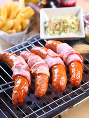 Grilled sausages with bacon and salad vegetables