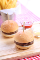 Two homemade hamburgers on wooden board