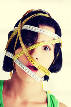 Beautiful young woman with measuring tape